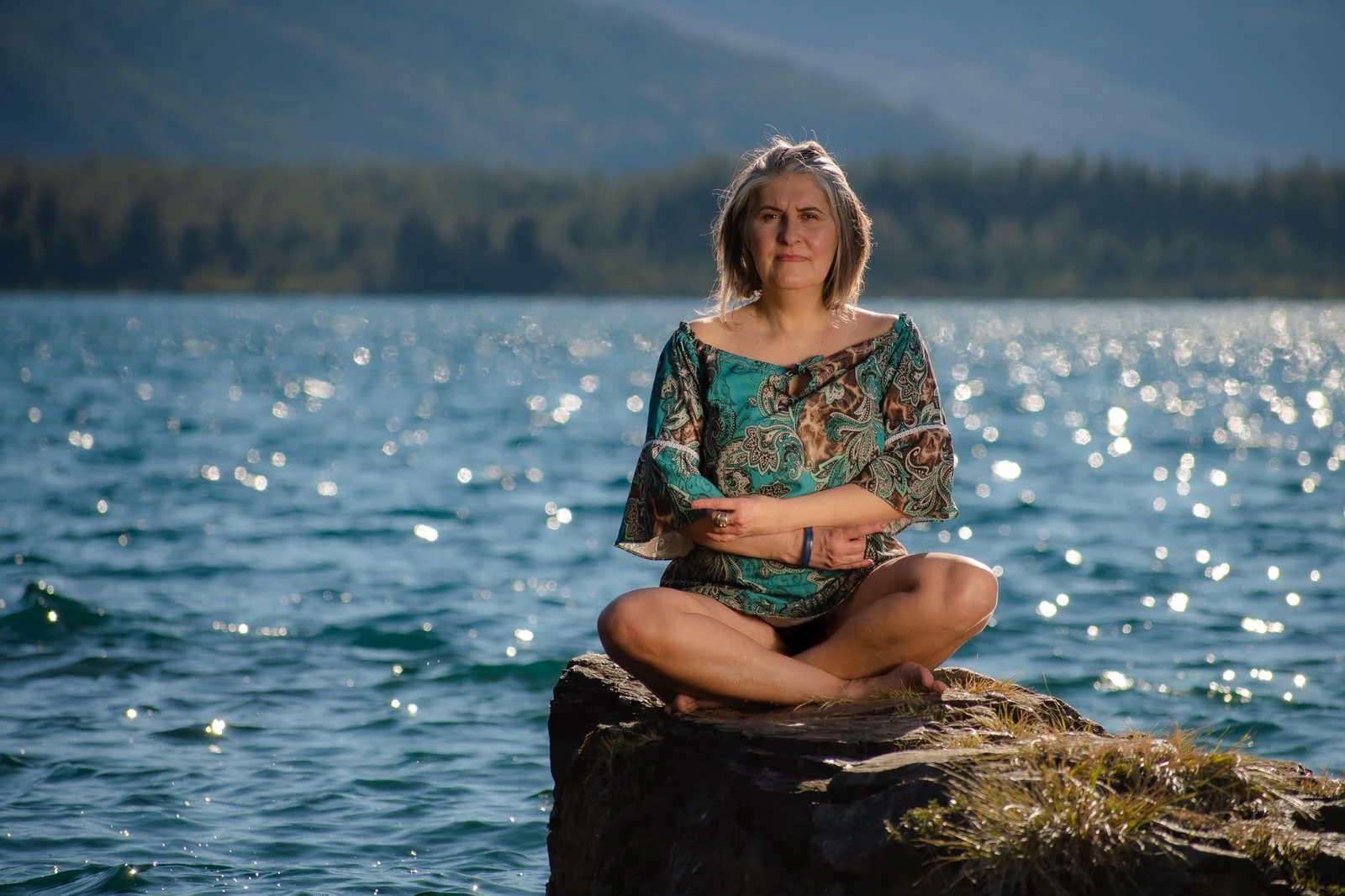 Flaviah Motta meditando à beira de um lago